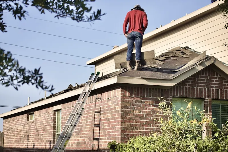 Professional roofer working on a residential roof in Maud